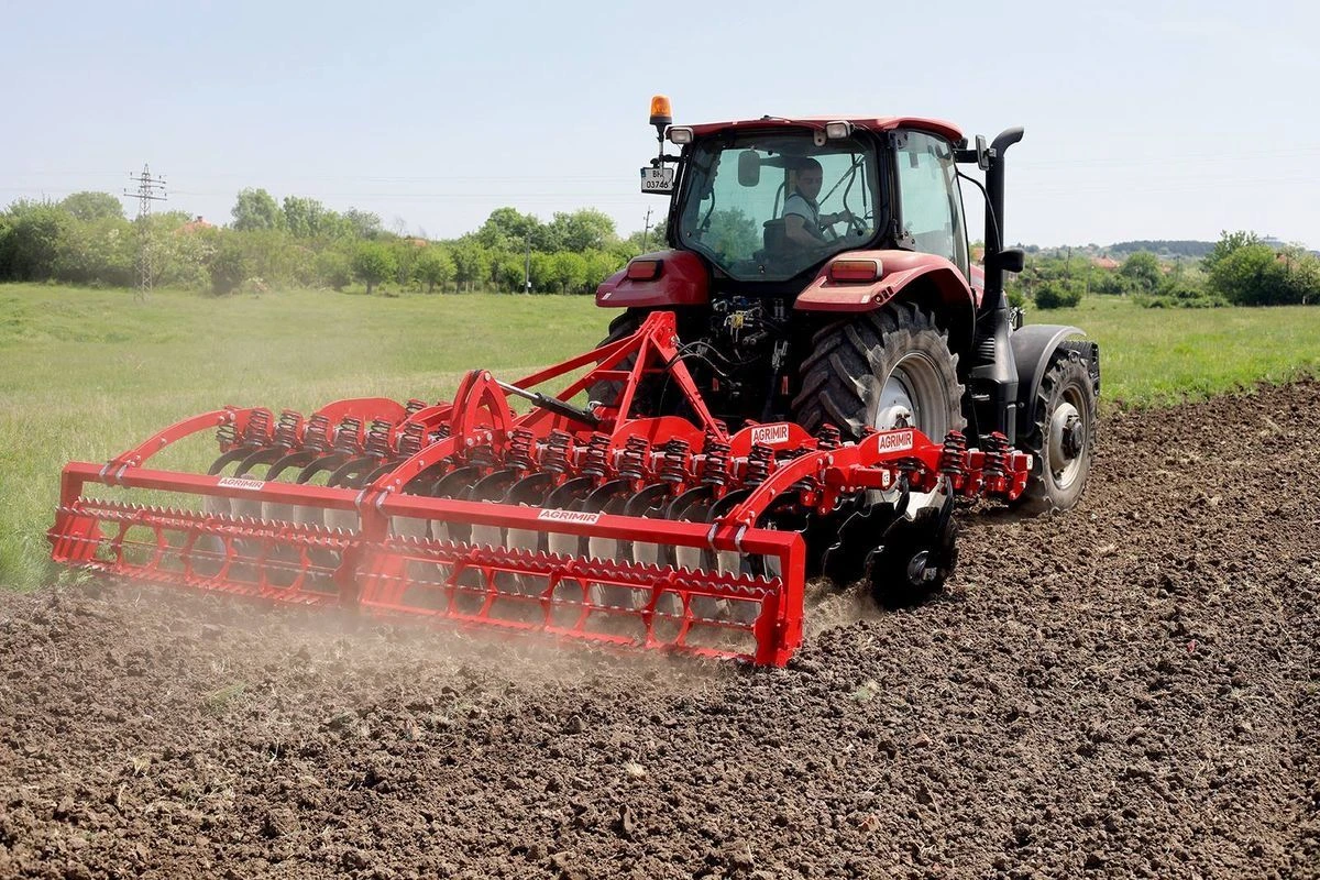 Single acting cylinder on an agricultural loader and trailer attachment